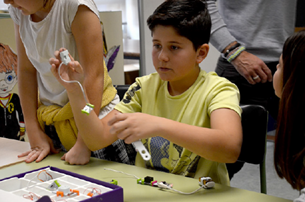 Un niño sentado en una mesa

Descripción generada automáticamente con confianza media